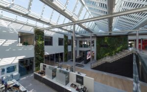 Glazen dak boven een atrium met groenwand