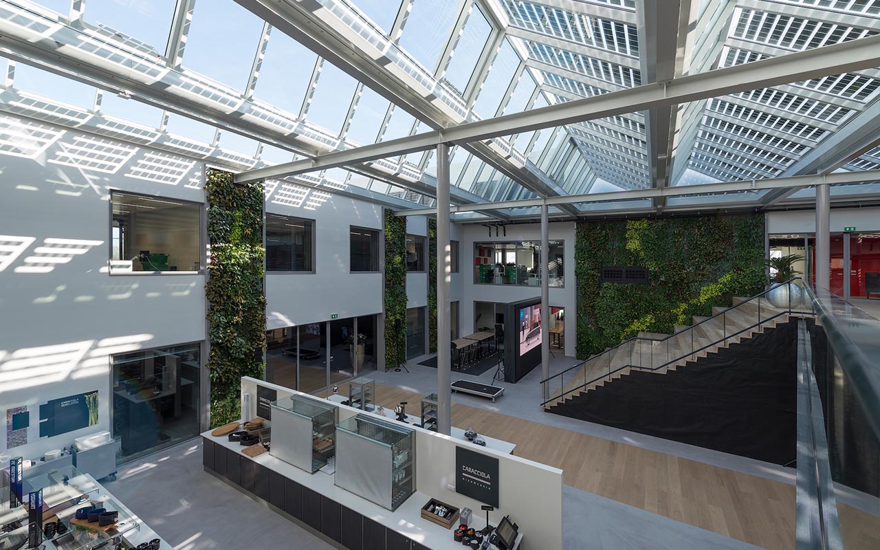 Glazen dak boven een atrium met groenwand