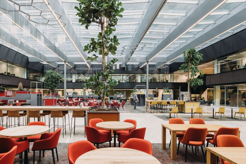 Restaurant met rode stoelen onder het glazen dak van EDGE Fellenoord