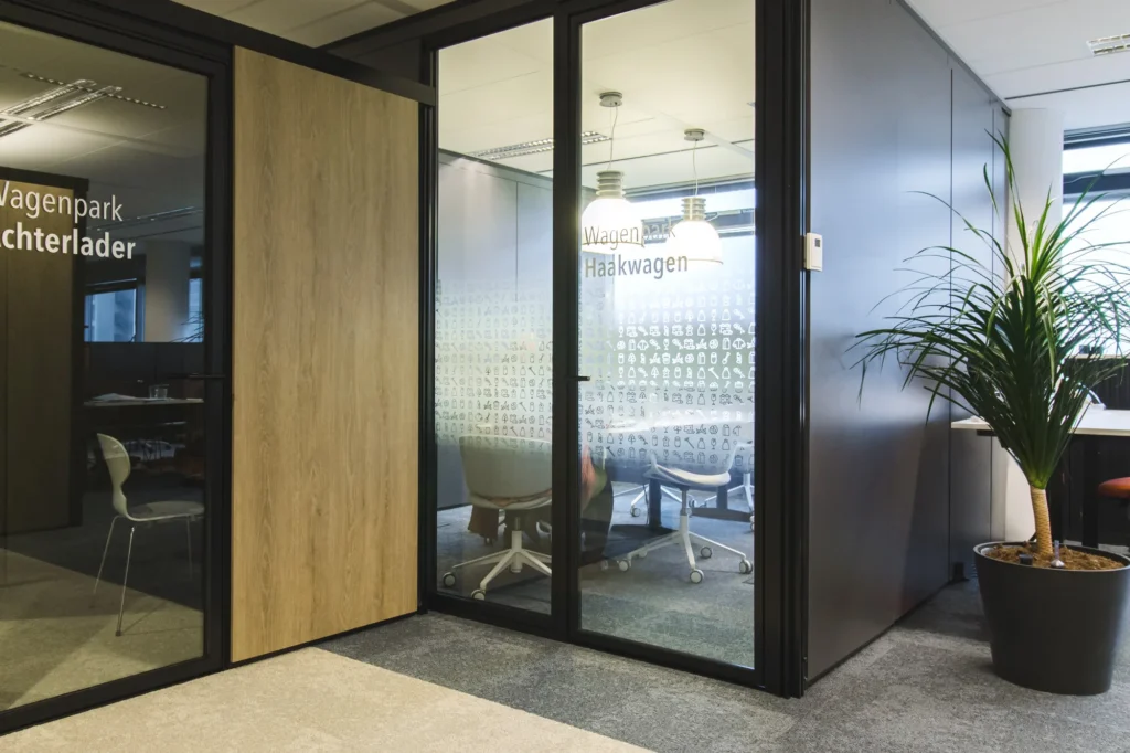 Glazen vergaderkamers met houten wand en plant