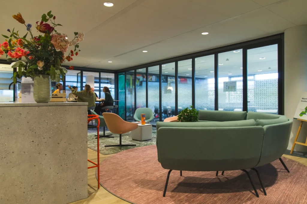 Lounge met groene bank en bloemen