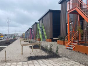 Paviljoens met oranje en groene buitentrappen langs een nieuwe straat